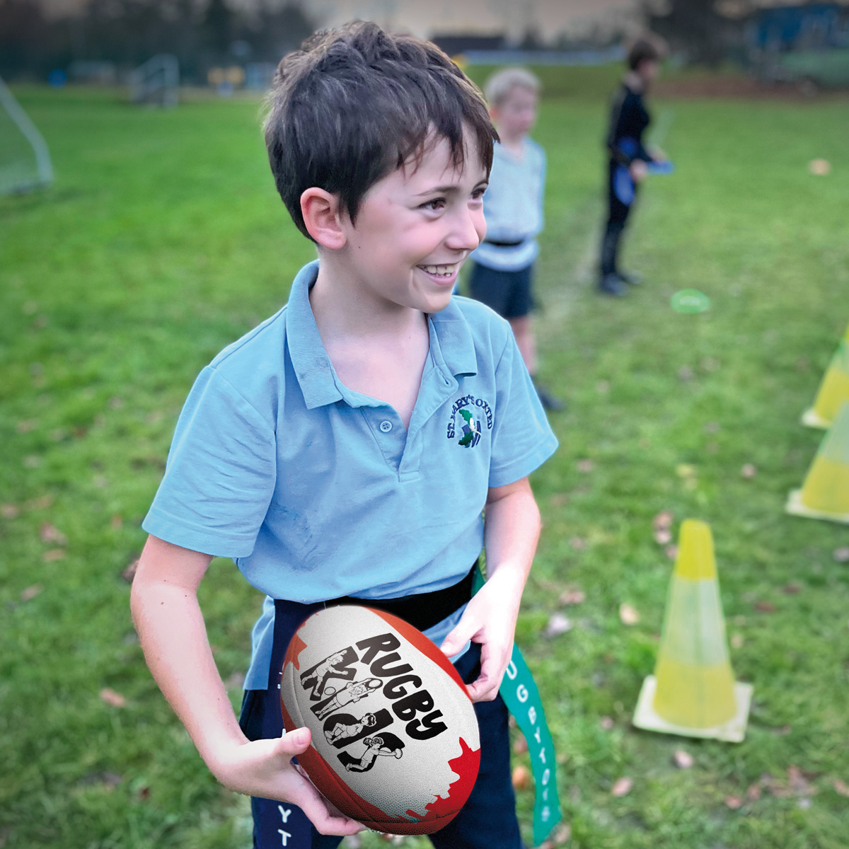 Schoolchild holding a rugby ball in a RugbyKids curriculum lesson