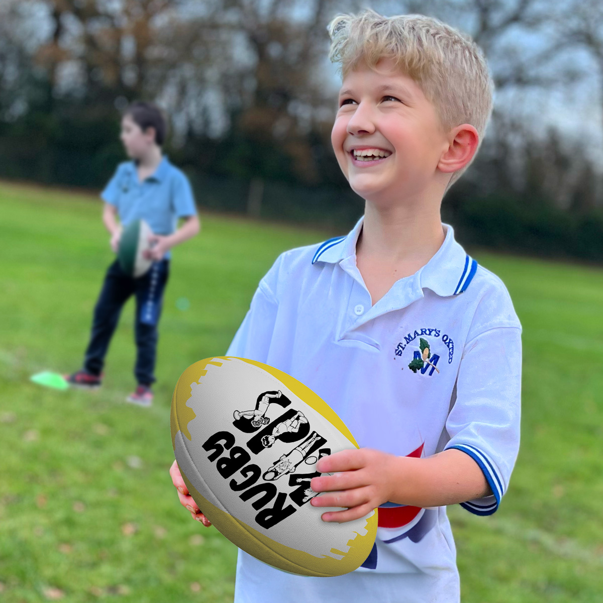 Happy child with a rugby ball in a RugbyKids curriculum lesson